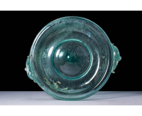 Ca. 100 BC - AD 100.A Roman free-blown shallow glass bowl with an applied disc foot. The bowls interior curves inward slightl