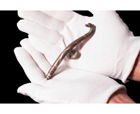 Ca. 771 - 256 BC. A silver-inlaid bronze belt hook with a dragon head from the Warring Period. The belt hook is inlaid with g