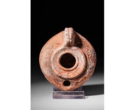 Ca. 300 - 200 BC.A Greek oil lamp with a large hole adorned with a raised frame. It is adorned with geometric moulded decorat