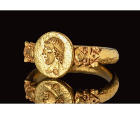 Ca. AD 200 - 300.A Roman gold ring with a round hoop that flattens at the shoulders. There are lion protomes which connect to