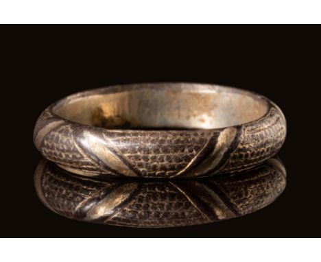 CA. AD 1300.A rare British medieval gilded silver ring with round D-section. The ring is embellished with diagonal, concave g