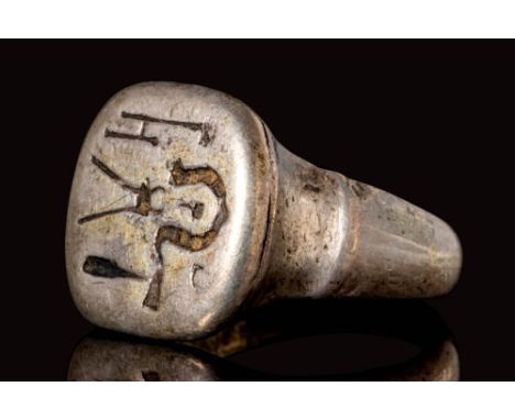 CA. 1600 AD.A post-medieval silver ring with a square bezel, adorned with a horseshoe and a set of callipers. This most likel
