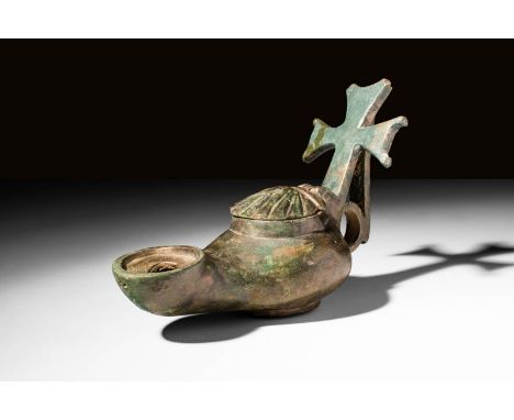 Ca. AD 500 - 700.A Byzantine bronze oil lamp with a potent cross handle. There is a large filling hole in the centre which is