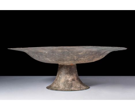 Ca. AD 1000 - 1200. A silver inlaid brass tray of annular form. The tray sits on a high pedestal on a rounded base, with shor