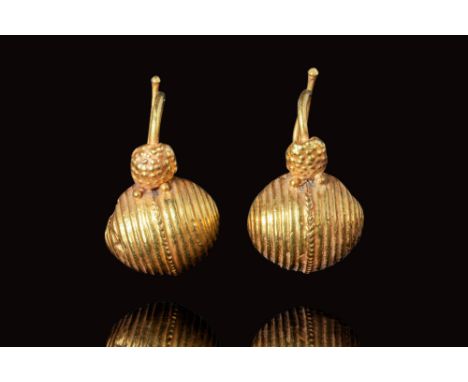 Ca. 500 - 300 BC.A matching pair of Hellenistic hollow gold earrings. Embellished with ribbed decoration along the main body 