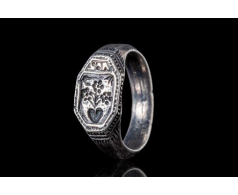 Ca. AD 1400. A medieval silver merchant ring with an irregular octagonal bezel, depicting a coat of arms surrounded by a fram