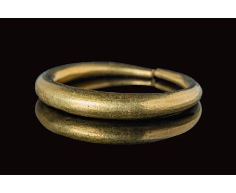 Ca. AD 400 - 600.A Saxon Era solid gold ring with a polished round hoop and conical section that tapers at the edges. For sim