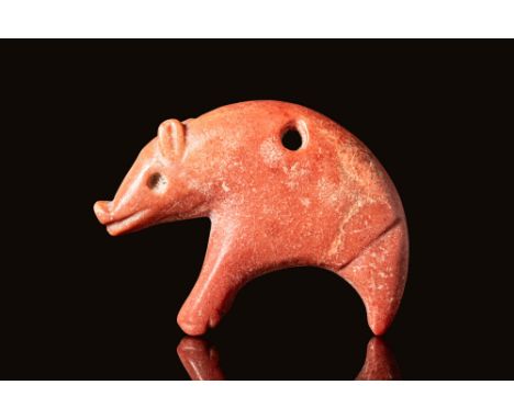 Ca. 3000 - 2500 BC.A Mesopotamian red stone amulet of a standing pig. It is depicted with an arched back and it's head down. 