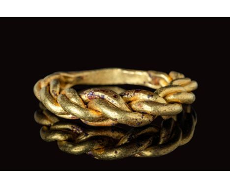 Ca. AD 800 - 1100.A Viking solid gold ring with a round hoop, formed from four intertwined strands. The strands taper into a 
