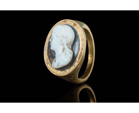 Ca. AD 100 - 200.A Roman gold ring with a round hoop which enlarges on the shoulders to form a high circular bezel that secur