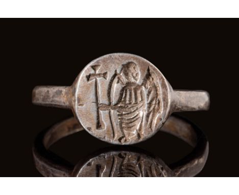 Ca. AD 500 - 700.A Byzantine silver ring composed of a round tubular hoop connected to a round bezel engraved with a standing