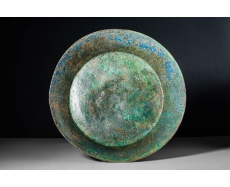 Ca. 500 - 300 BC.An Etruscan cast-bronze bowl, with a large flat base, high diagonal walls and a large rim. Russet and green 