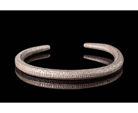 Ca. AD 800 - 1100.An elegant, hammered silver bracelet with a circular form and tapered ends with a narrow opening between th