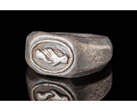 Ca. AD 100 - 300.A Roman cast silver ring with a large polygonal round hoop. Upon the shoulders lays a flat bezel embellished