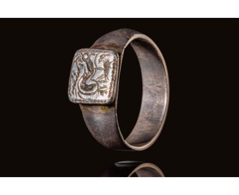 Ca. AD 600 - 800.A Merovingian silver ring with a round hoop and a square bezel, which depicts a marine scene with a stylised