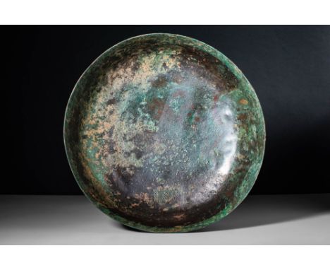 Ca. 500 - 300 BC.An Etruscan cast-bronze bowl with a large flat base, high walls and a vertical large rim. Russet and green p