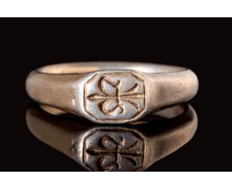 Ca. AD 1100 - 1300.A Crusaders silver seal ring with a polygonal bezel featuring a fleur-de-lis surrounded by an octagonal fr