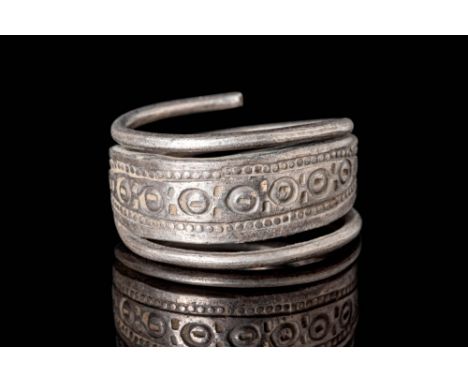 Ca. AD 800 - 1100.A silver Viking ring that is shaped from a hammered sheet of silver with tubular terminals along the unders