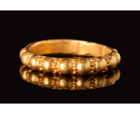 Ca. AD 700 - 900.A Viking gold ring with a round hoop decorated with protruding large spheres, alternating with lines of smal