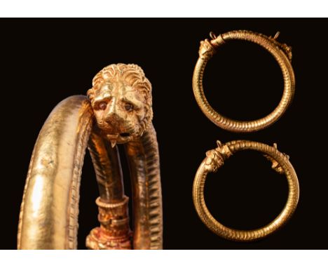 Ca. 400 - 300 BC. A pair of Hellenistic bracelets with a ribbed cylindrical body and lion head finials, with deep set eyes an