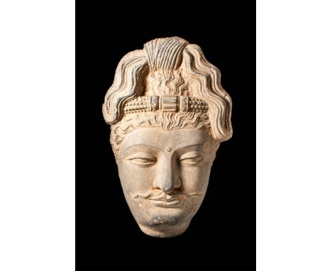 Ca. AD 200 - 600.A Gandhara schist head of Bodhisattva, with an elaborately decorated ushnisha knot. The face depicts a seren