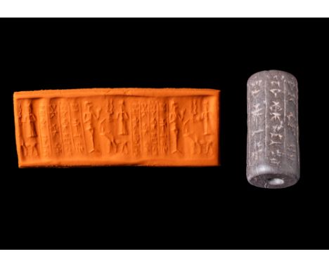 Ca. 1900 - 1700 BC. A Babylonian dark brown stone cylinder seal. On the right of the stamped design, is the storm god Adad in