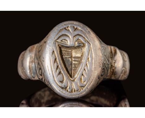 Ca. AD 1400 - 1500.A medieval merchant’s silver ring with an oval bezel, depicting a coat of arms. The shield at the centre a