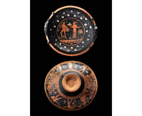 Ca. 330 - 300 BC. An Apulian patera with red figures covered in black paint with white and yellow added details. The vessel i