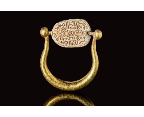 Ca. 2055 - 1790 BC.A beautiful grey steatite scarab that is affixed on the top of a gold hoop, that is enlarged on the bottom