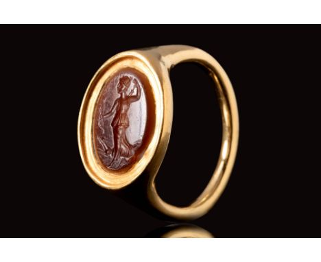 Ca. AD 100 - 300.A Roman red/ orange carnelian intaglio depicting the goddess Diana, set in a high carat, possibly later gold