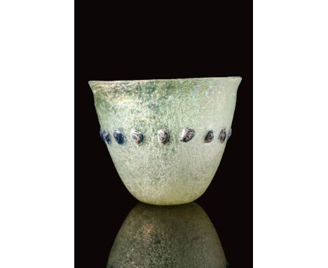 Ca. AD 400 - 600.A late Roman translucent glass beaker. The beaker has a gently-flaring profile with thin walls, a deep inter