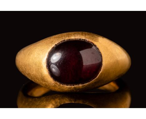 Ca. AD 400 - 600.A Merovingian gold ring with an oval bezel, securing a large red garnet cabochon.Size: D:12.9mm / US: 1 1/2 