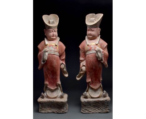 Ca. 618-906 AD.An exceptional pair of Tang dynasty terracotta male dignitaries, each standing on a raised base. The figures a