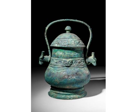 Ca. 1046-771 BC.A Western Zhou period bronze wine vessel. A typically shaped you vessel, with a high-collared lid and a semi-