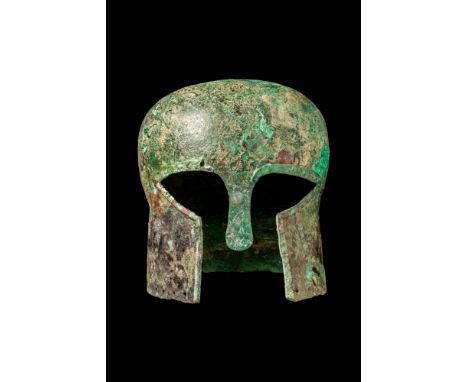 Ca. 500 - 400 BC.A rare Corinthian helmet, hammered from a single heavy bronze sheet, with a long, tapered cheek-pieces. The 
