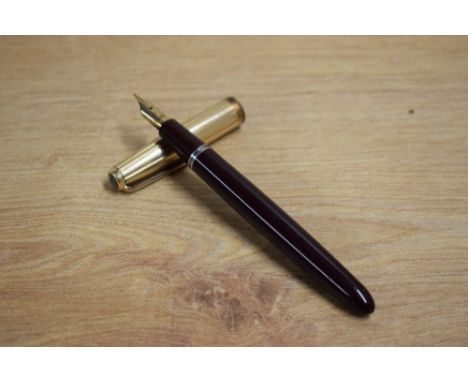 A Parker La Plume Lamine aerometric fill fountain pen in burgundy with rolled gold cap having Parker 14ct  nib. Slight wear t
