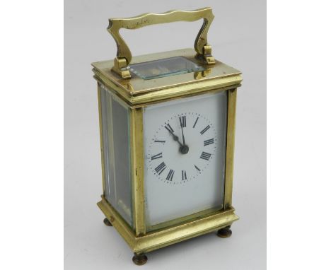 An early 20th century French carriage clock, the white enamel dial with Roman numerals, the brass case with swing handle, dru
