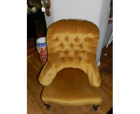 A Victorian button upholstered tub chair, upholstered in gold fabric and raised on short turned legs.