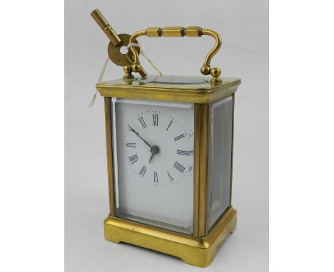 An early 20th century lacquered brass carriage time piece, the rectangular white enamel dial marked Roman numerals.