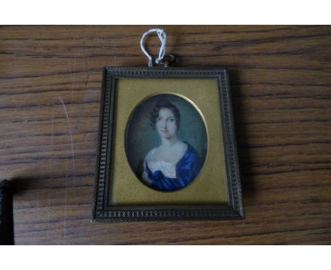 Oval portrait miniature 19thc young lady in blue dress in gilt metal frame on ivory. 6.3cms.