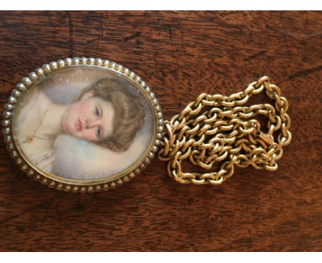 Miniature portrait in 9ct gold frame surrounded by seed pearls on a 15ct gold chain.