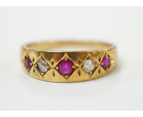 An early 20th century yellow metal ruby and diamond set five stone dress ring, size P