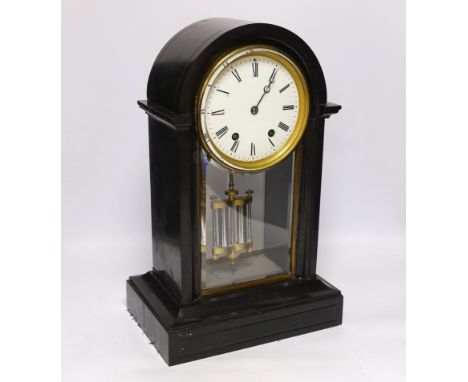 A slate cased domed mantle clock, with enamelled dial striking on a bell, with black Roman numerals above a bevelled glazed t