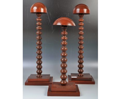 A fabulous group of three 20th Century vintage stained mahogany mushroom topped shop / haberdashery hat / wig display stands.