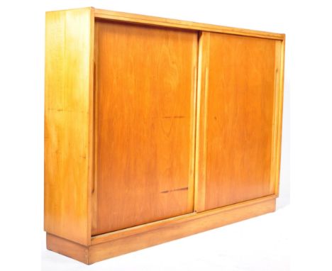 A mid Century light oak Air Ministry / school cupboard of oak construction having two large blind fronted&nbsp; sliding doors