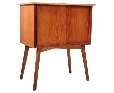 A mid 20th Century retro vintage record cabinet of teak construction having twin sliding doors with recessed handles and flar