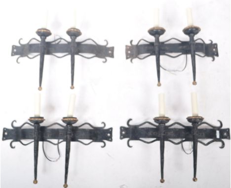 A set of four antique Gothic revival wrought iron wall sconces. The body fashioned from antique iron brackets, with fluted fi