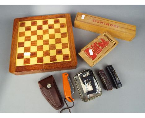 A mixed lot to include a chess set, box of additional Staunton chess pieces, boxed dominoes, dice games, knives and similar.