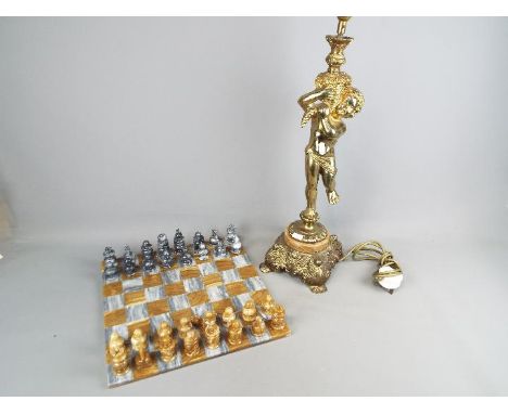 A brass and onyx table lamp depicting a putto holding aloft a cornucopia, approximately 62 cm (h) including light fitting and