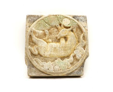 A Chinese pottery wall tile, Han Dynasty, moulded with a deer beneath clouds, in a raised circular surround, with coloured pa